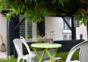 a green table and white chairs in a yard at Walygator Agen aqualand ,canal des deux mers in Le Passage