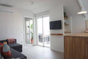 アロナにあるSweet Home Los Cristianosのソファとテレビのあるリビングルーム