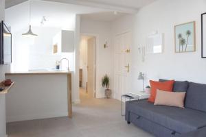 アロナにあるSweet Home Los Cristianosの青いソファとキッチンのあるリビングルーム