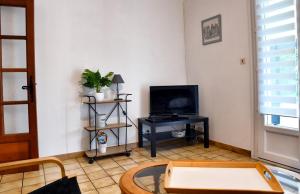 a living room with a tv and a table at Walygator Agen aqualand ,canal des deux mers in Le Passage