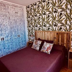 a bedroom with a bed and a wall with blue doors at Paradise Apartment in Corralejo