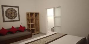 a bedroom with a bed and a couch and a window at Kapri Balinese House in Ubud