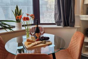 a glass table with a bottle of wine and grapes at Near beach, Modern and Spacious 4 Bedroom House, Hot Tub, Wifi, Netflix, Parking in Paignton