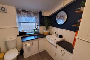 a bathroom with a toilet and a sink and a window at Near beach, Modern and Spacious 4 Bedroom House, Hot Tub, Wifi, Netflix, Parking in Paignton