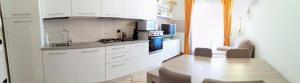 a kitchen with white cabinets and a wooden table at Casa Roberto in Susegana