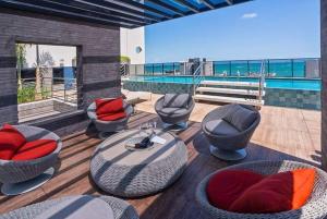 a patio with chairs and tables and a pool at Studio 818 no edf. TIME, Ponta Verde in Maceió