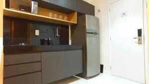a kitchen with a stainless steel refrigerator and a microwave at Studio 818 no edf. TIME, Ponta Verde in Maceió