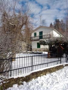 een wit huis met een hek in de sneeuw bij Casa vacanza Il Poggio in Saragiolo