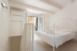 ドンナルカータにある"Le Casette di Ninetta" - Casa vacanza Miccichèの白いベッドルーム(ベッド1台、バルコニー付)