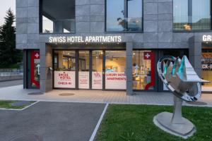 una tienda frente a un edificio con un banco delante en Swiss Hotel Apartments - Interlaken, en Interlaken