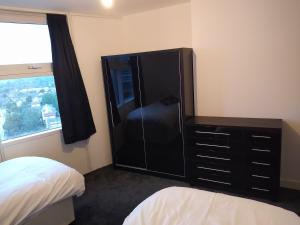 a bedroom with a dresser and a black cabinet at Room in Luxurious Penthouse Apartment in London +10 photos