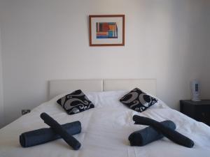 a bed with black pillows and black socks on it at Room in Luxurious Penthouse Apartment in London
