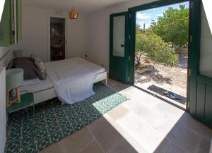 een slaapkamer met een bed en een glazen schuifdeur bij Casa Amahoro in Ostuni +49 foto's