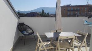 - un balcon avec une table, des chaises et un parasol dans l'établissement Casa Vacanza Le Nid d'Assise, à Bastia Umbra