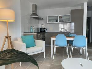 une cuisine et un salon avec des chaises bleues et une table dans l'établissement LC Bastian Marina Bungalow, à Costa Teguise