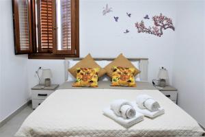 a bedroom with a bed with towels on it at Pozzo Antico Apartments in San Vito lo Capo