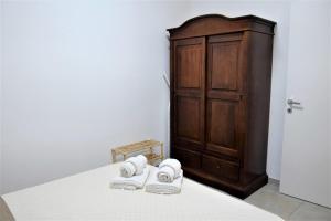 a room with a bed with towels and a wooden cabinet at Pozzo Antico Apartments in San Vito lo Capo +40 photos