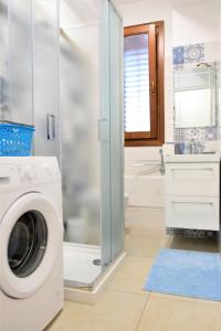 a washing machine in a bathroom with a shower at Pozzo Antico Apartments in San Vito lo Capo