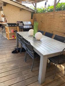 a wooden table and chairs on a deck at Les chambres d'hôtes de la croix bleue in Murinais