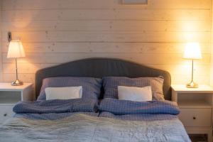 a bedroom with a bed with pillows and two lamps at Lawendowe Pole - Domek Lawendowy in Nowe Kawkowo