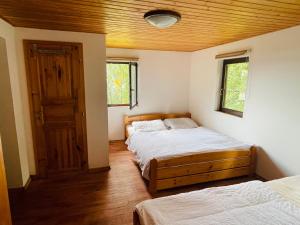 a bedroom with two beds and a wooden ceiling at Chata Adam u Lipna in Horní Planá