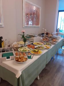 stół z wieloma talerzami jedzenia w obiekcie Hotel Le Macine w mieście Montaione