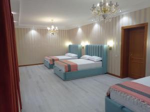 a hotel room with two beds and a chandelier at Comfortable Home Stay in Termiz