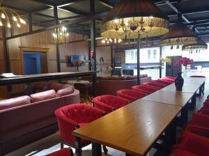 a restaurant with a wooden table and red chairs at Comfortable Home Stay in Termiz