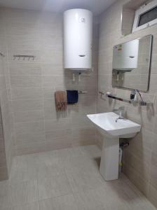 a white bathroom with a sink and a mirror at Comfortable Home Stay in Termiz