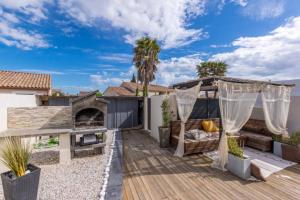 a backyard with a wooden deck with a patio at Villa avec piscine au calme 6 personnes in Valros