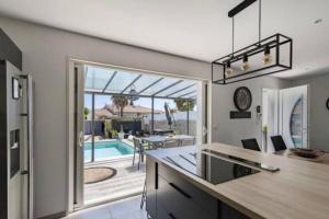 a kitchen with a view of a swimming pool at Villa avec piscine au calme 6 personnes in Valros