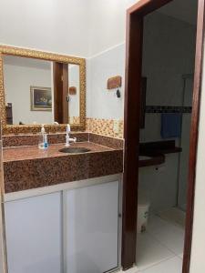 a bathroom with a sink and a mirror at Residencial Granito e Jasmim Flat em Jacumã vista para o Mar in João Pessoa