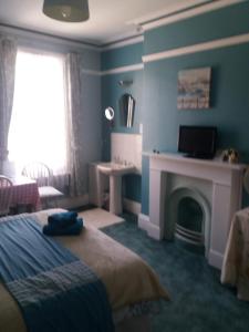 een blauwe slaapkamer met een bed en een open haard bij Kew Gardens National Archives Forest Road in Londen