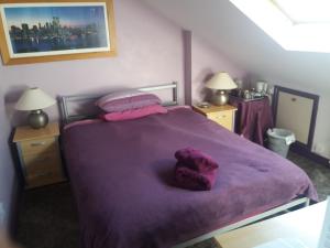 a bedroom with a bed with purple sheets and pillows at Kew Gardens National Archives Forest Road in London