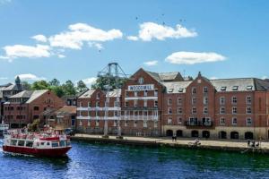 un barco en el agua frente a un edificio en The Riverside at Woodsmill Quay with parking, en York