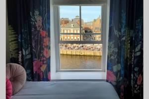 1 dormitorio con ventana y vistas al agua en The Riverside at Woodsmill Quay with parking, en York