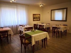 ein Restaurant mit Tischen und Stühlen mit weißem Tischtuch in der Unterkunft Grand Bells Bed And Breakfast in Zagreb
