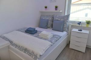 Un dormitorio con una cama con almohadas azules y una ventana en Moderne,helle und ruhige Wohnung zur Alleinnutzung, en Mindelheim