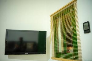 einen Flachbild-TV an einer Wand neben einem Fenster in der Unterkunft Casa Antoñita, El lugar perfecto para descansar in Muñique