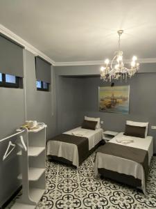 a bedroom with two beds and a chandelier at HHK Hotel in Istanbul