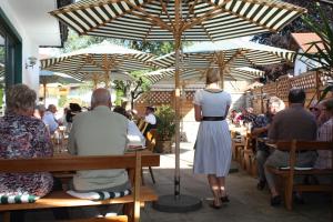 a woman standing under an umbrella at a restaurant at Hotel Christl in Rohrdorf