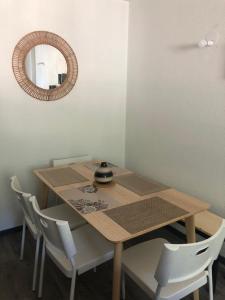 een eettafel met stoelen en een spiegel bij Appartement refait à neuf 40m2, Cauterets Centre in Cauterets