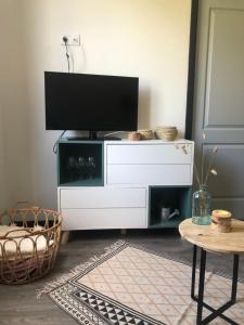 een woonkamer met een tv op een wit entertainmentcentrum bij Appartement refait à neuf 40m2, Cauterets Centre in Cauterets