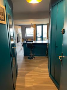 un couloir menant à une cuisine aux murs bleus dans l'établissement Deauville marina - Escapade vue mer, à Deauville