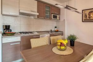 kuchnia ze stołem, na którym stoi miska z owocami w obiekcie Apartments in Stara Baska - Insel Krk 34433 w mieście Stara Baška