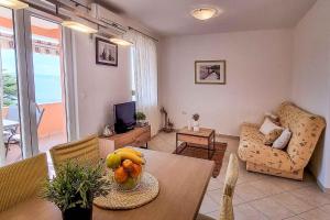 salon ze stołem, na którym leżą owoce w obiekcie Apartments in Stara Baska - Insel Krk 34433 w mieście Stara Baška