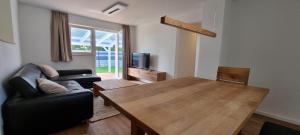 ein Wohnzimmer mit einem Holztisch und einem Sofa in der Unterkunft FN Oak Bungalow in Friedrichshafen