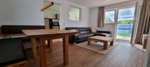 sala de estar con mesa y sofá en FN Oak Bungalow en Friedrichshafen