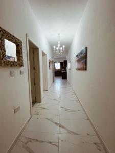 a hallway with white walls and a tile floor at Sun Sea Living Gozo in Xlendi