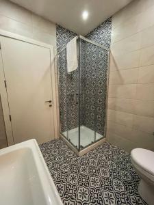 a bathroom with a shower with a tub and a toilet at Sun Sea Living Gozo in Xlendi